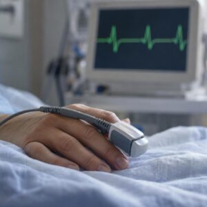 Μακροφωτογραφία καρδιακού παλμού σε μόνιτορ και ανθρώπινο χέρι σε φως